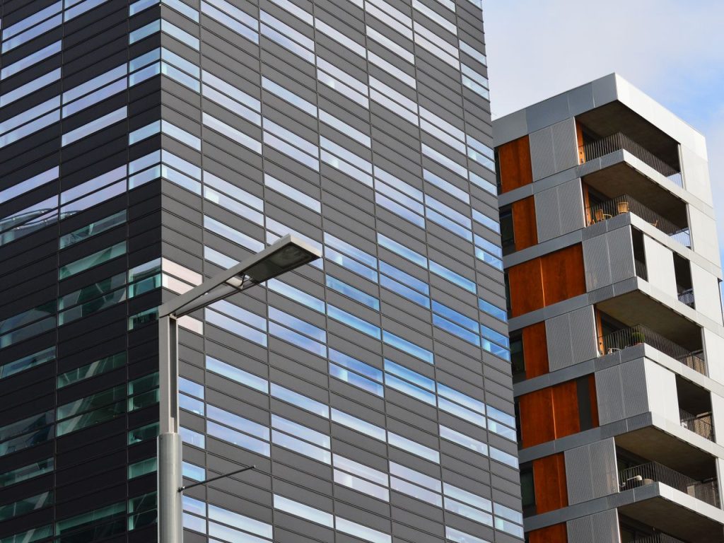 Crafting Captivating Headlines: Your awesome post title goes here Low angle view of a modern glass office building and residential structure in daylight.