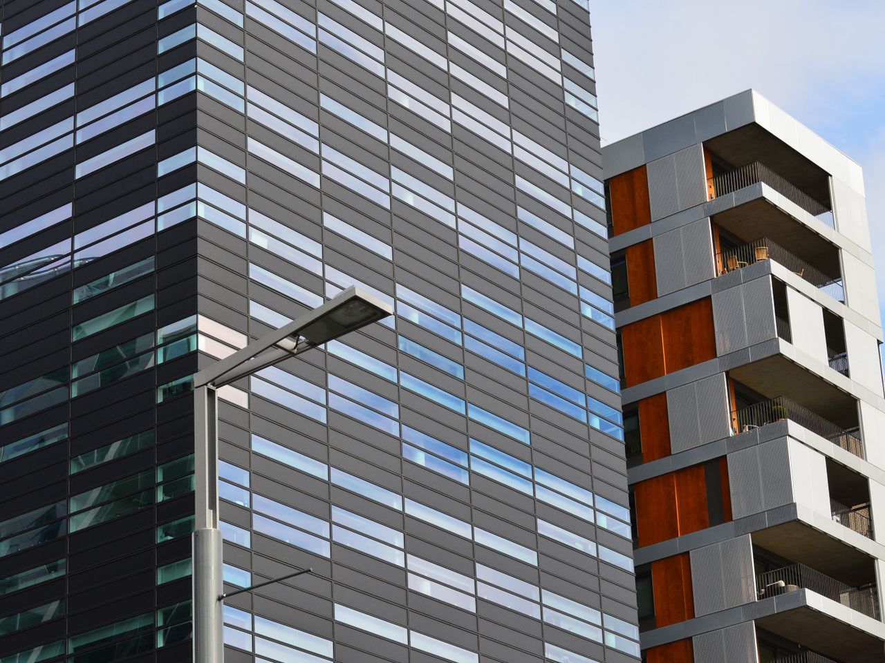 Crafting Captivating Headlines: Your awesome post title goes here Low angle view of a modern glass office building and residential structure in daylight.