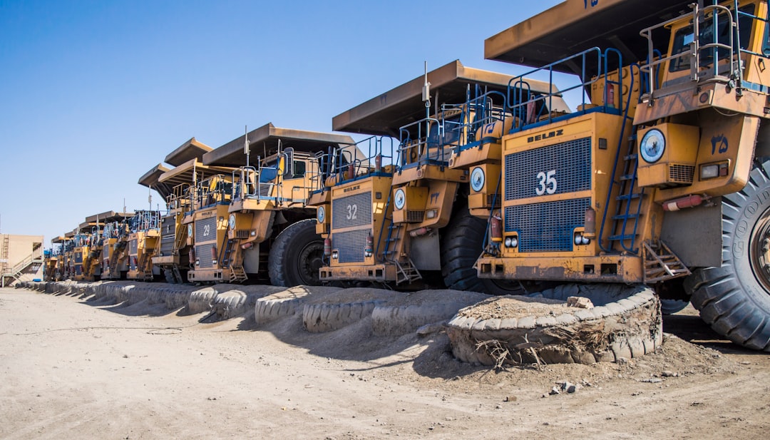 services-01 a-row-of-large-yellow-trucks-parked-next-to-each-other-7nn346qezkg
