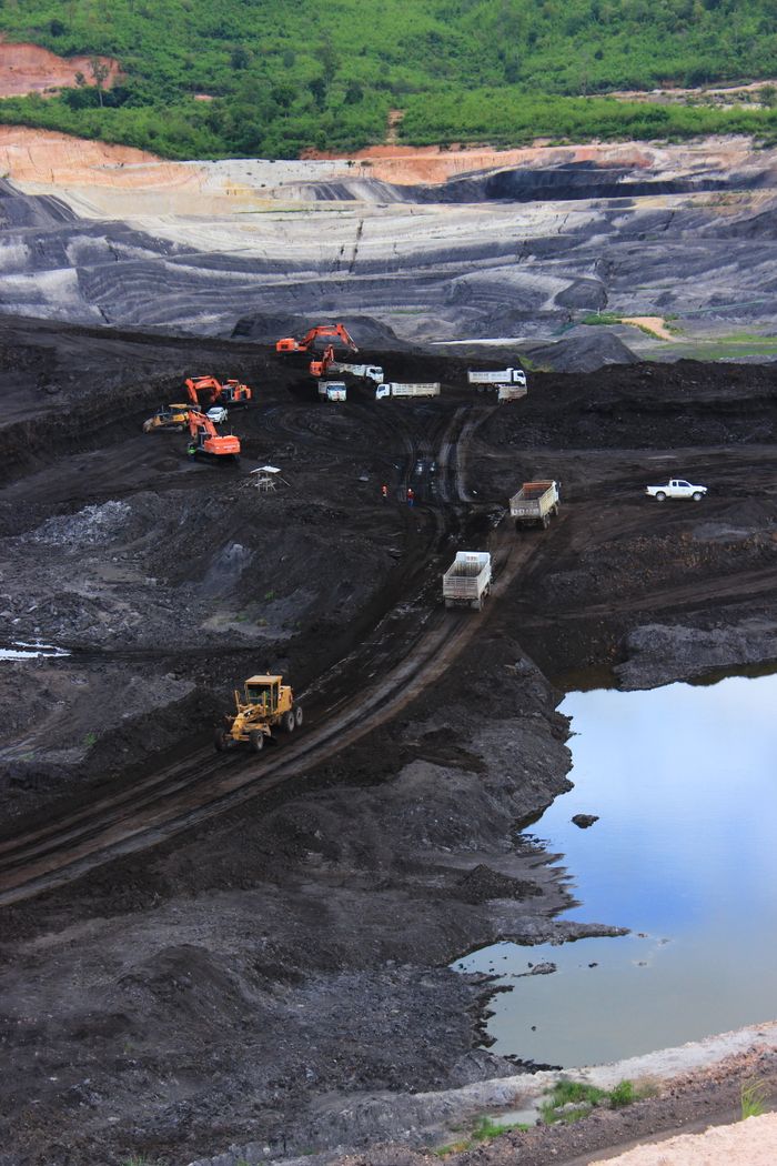 about-me-01 Aerial photograph showcasing machinery working in a vast open-pit mining site.